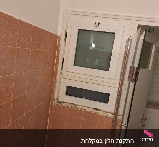 חלון אלומיניום בחדר אמבטיה עם אריחים כתומים